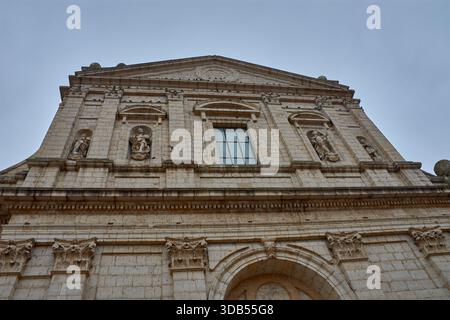 Una prospettiva dall'angolo basso mette in risalto l'imponente facciata in pietra di stile classico di questo edificio religioso, che mostra dettagli architettonici come Foto Stock