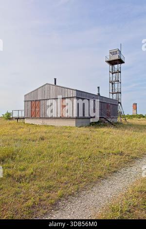 Ex posto di guardia di frontiera sovietica o torre di guardia e edificio con faro Loode sullo sfondo in estate, Türju, Saaremaa, Estonia. Foto Stock