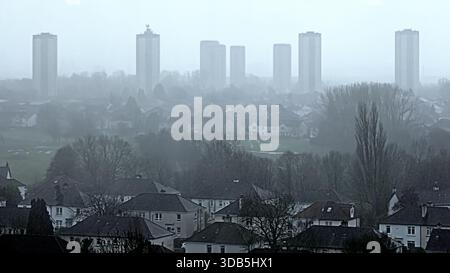 Glasgow, Scozia, Regno Unito. 14 dicembre 2025. Meteo nel Regno Unito: La città coperta da nuvole scure, vento e pioggia mentre la gente del posto lottava per le strade della città visibilità limitata nascondeva le colline nel nord della città. Credit Gerard Ferry/Alamy Live News Foto Stock