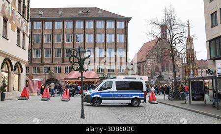 14 dicembre 2025, Baviera, Norimberga: I dissuasori e un autobus della polizia antisommossa garantiscono l'ingresso al mercatino di Natale di Norimberga. Il ministro degli interni bavarese Herrmann (CSU) ha parlato domenica a Norimberga dell'arresto di diversi uomini nella bassa Baviera che avrebbero pianificato un attacco a un mercatino di Natale con un veicolo. Foto: Daniel Löb/dpa Foto Stock