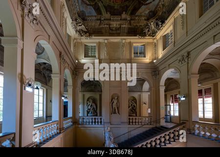 Bologna, Italia - 23 luglio 2025: Grande scalinata di Palazzo Ercolani a Bologna, con statue in stucco barocco, gallerie ad arco e riccamente dipinte Foto Stock