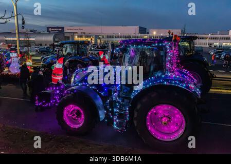 Basildon Christmas Tractor Run 2025 lascia lo stabilimento New Holland, Essex, Regno Unito. Trattore illuminato all'esterno dell'impianto di produzione di trattori Basildon Foto Stock