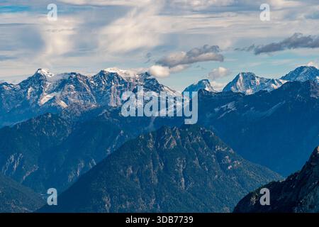 Una vista panoramica mozzafiato delle creste alpine innevate immerse nella luce soffusa d'autunno evoca serenità e avventura durante un'escursione panoramica attraverso il Foto Stock