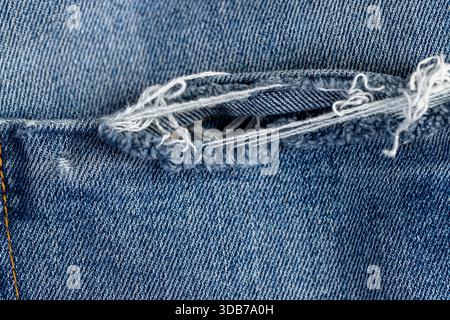 vecchi jeans blu strappati a lungo termine, parte di jeans blu realizzati in tessuto di cotone sfilacciato e strappato per un uso prolungato Foto Stock