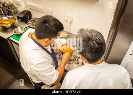 Cuoce a preparare il cibo nella cucina di un ristorante Foto Stock