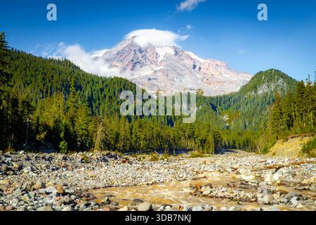 Una vista panoramica cattura il Monte Rainier che torreggia sul bellissimo fiume Paradise, come si vede dal Carter Falls Trail nel Mount Rainier National Foto Stock
