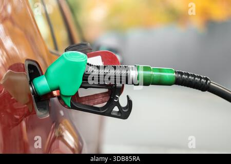 Ugello di rifornimento nel serbatoio del carburante dell'auto alla stazione di rifornimento, primo piano Foto Stock