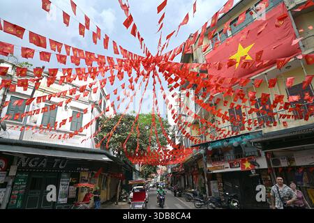 Le bandiere del Vietnam del Partito Nazionale e Comunista fiancheggiano le stradine del quartiere Vecchio di Hanoi, il cuore storico della città Foto Stock