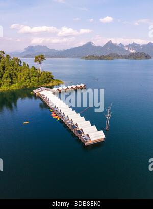 Scoprite la tranquilla bellezza del Lago Cheow LAN, caratterizzato da pittoreschi bungalow galleggianti circondati da lussureggiante vegetazione e maestose montagne. Una fuga perfetta per gli amanti della natura e dell'avventura. Foto Stock