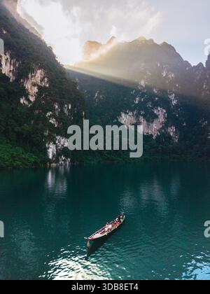 Scopri la tranquilla bellezza del lago Cheow LAN a Khao Sok, Thailandia, mentre la luce del sole danzava sull'acqua. Foto Stock