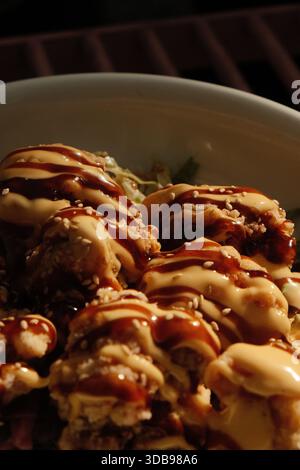 Primo piano di involtini di salmone splendidamente placcati conditi con maionese piccante, una deliziosa esperienza culinaria. Foto Stock