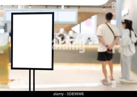 Cartellone vuoto in un bar o ristorante moderno con i clienti che ordinano al bancone, ideale per l'esposizione di menu, la promozione, il mockup pubblicitario, Foto Stock