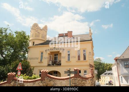 Splendida villa gialla con dettagli architettonici unici, un affascinante edificio storico con graziosi elementi da giardino. Foto Stock
