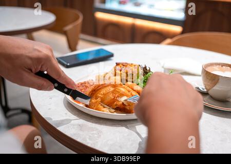 Un uomo che fa una grande colazione occidentale in un ristorante. Vista ravvicinata. Foto Stock