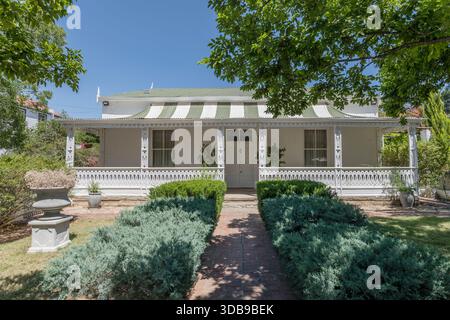 Paesaggio urbano con struttura a portico in legno ornato aperto in una tradizionale e pittoresca casa sul giardino, ripresa dalla luce della tarda primavera, Graaff-Reinet, Foto Stock