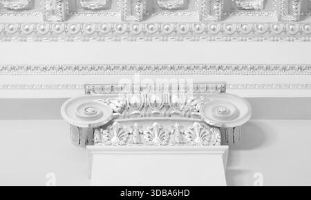 Il portico decorativo presenta una colonna ionica che mostra intricati dettagli bianchi sulla capitale Foto Stock