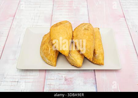 Le classiche empanadas di merluzzo, fritte fino a croccanti all'esterno, servite su salviette di carta per assorbire l'olio in eccesso Foto Stock
