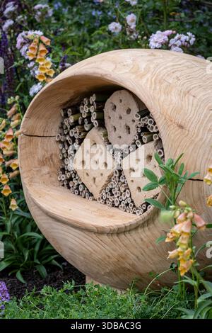 Hotel su misura per insetti in legno, circondato da giardini e animali selvatici Foto Stock