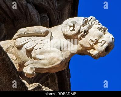 Un gargoyle di ariete alato è visibile sulla facciata gotica della cattedrale di Siviglia sotto un cielo blu brillante. Si tratta di una scultura dettagliata che si aggiunge all'architetto Foto Stock