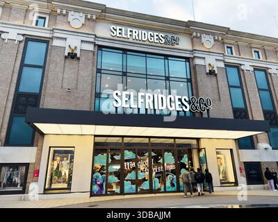 Manchester, Regno Unito - 15 novembre 2025: Vetrina di Selfridges Manchester con arredamento natalizio e clienti che entrano nelle porte di vetro luminose. Foto Stock