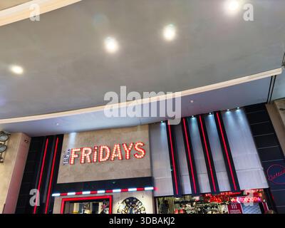 Stretford, Regno Unito - 15 novembre 2025: Luminoso TGI Fridays esterno a Manchester, Regno Unito con segnaletica al neon e moderno ripiano. Foto Stock