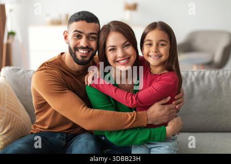 Happy Arab Family ama trascorrere momenti di qualità a casa, condividere sorrisi e abbracci sul divano Foto Stock