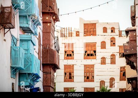 Veduta aerea di edifici dal design complesso con traliccio in legno e vivaci balconi turchesi che si affacciano sulle pareti soleggiate di al-Balad, Foto Stock