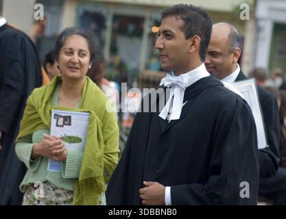 Studenti universitari di Cambridge di origine bianca ed etnica minoritaria che si diplomano presso i loro college indossando la tradizionale fascia e abito accompagnati dai loro maestri , procedendo verso la casa del senato per ricevere la laurea. Foto Stock
