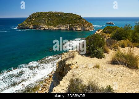 Isola dell'Isla del Portitxol e onde che si infrangono sulla riva dal punto panoramico del Mirador del Portichol (Jávea, Marina alta, Alicante, Mar Mediterraneo, Spagna) Foto Stock
