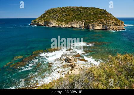 Isola dell'Isla del Portitxol e onde che si infrangono sulle rocce dal punto panoramico del Mirador del Portichol (Jávea, Marina alta, Alicante, Mar Mediterraneo, Spagna) Foto Stock