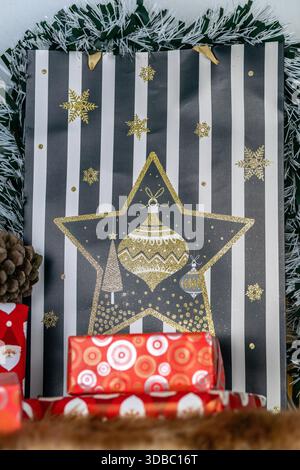 Un'immagine di regali di Natale colorati avvolti da decorazioni natalizie e ricoperti di tinsel Foto Stock