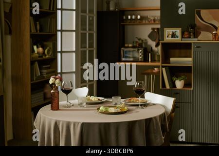 Cena romantica a tavola con bicchieri da vino e antipasti gourmet Foto Stock