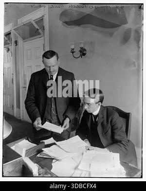 Foto storica di Rudolph Forster, segretario del presidente Theodore Roosevelt, che esamina documenti con un collega in un ufficio, 18 marzo 1903. Foto Stock