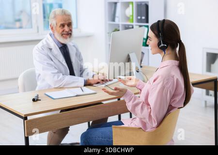 Paziente con cuffie audiometriche sottoposto a test uditivo in clinica Foto Stock