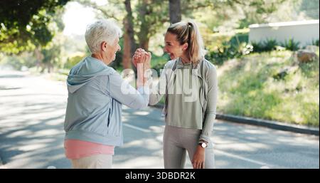 Donna anziana, personal trainer o fitness con cinque alti in strada per raggiungere il traguardo o allenarsi. Anziani, donna o allenatore con sorriso per Foto Stock