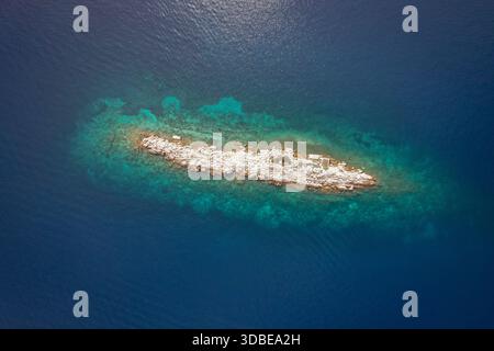 Vista aerea di una piccola isola rocciosa circondata dal mare blu profondo e dalle acque turchesi, Sipanska Luka, Dubrovnik-Neretva County, Croazia. Foto Stock