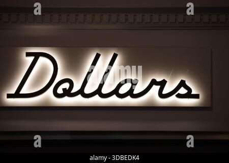 Dublino, Irlanda - 10 dicembre 2025 - Un cartello retroilluminato "Dollars" illuminato in George's Street, nella città di Dublino, raffigurante scene di strada nella capitale irlandese Foto Stock