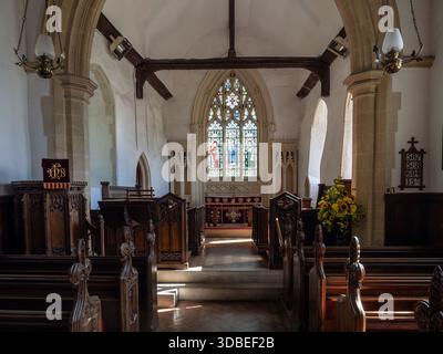 Interno della chiesa di Santa Maria, Aldham, Suffolk con navata storica, arco e tradizionali pali in legno Foto Stock