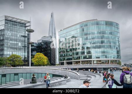 I turisti che camminano davanti agli altri edifici sul lungofiume di londra lungo la Queens Walk sulla South Bank di Londra nel Regno Unito in Europa. Foto Stock