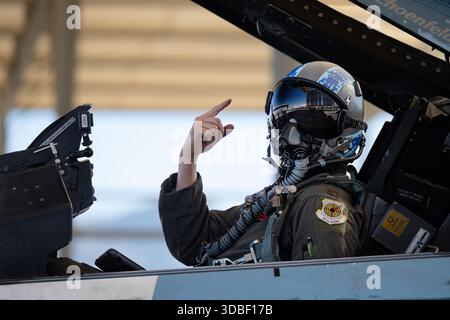 Nicholas Belinski, un pilota di F-16C Fighting Falcon assegnato al 64th Aggressor Squadron (AGR), utilizza segnali manuali per comunicare Foto Stock