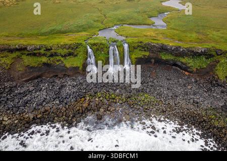 Una vista della spiaggia e delle scogliere costiere con cascate tra Arnarstapi e Budir sulla penisola di Snaefellsnes Foto Stock