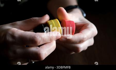 Le mani tengono insieme i magneti, illustrando le loro proprietà magnetiche mentre vengono separati, sottolineando l'interazione e il movimento. Alta qualità Foto Stock