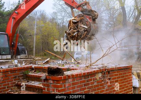 La macchina per costruzioni solleva i detriti dal sito in cui l'edificio è stato recentemente demolito nelle vicinanze. Foto Stock