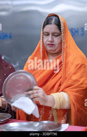 Una Sikh di mezza età che si offre volontaria nella cucina comune di langar. Nel Queens, New York. Foto Stock
