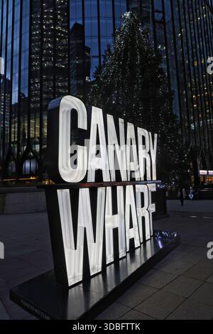 Cartello di testo illuminato di Canary Wharf e albero di Natale London Docklands Regno Unito dicembre 2025 Foto Stock