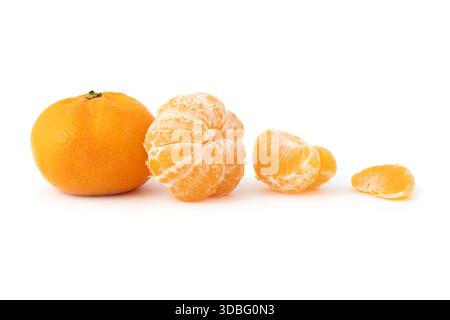 Mandarini interi e tagliati a fette con foglia verde su sfondo nero arancio mandarino Foto Stock