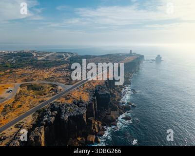 Fotografia aerea ad alto angolo di Cabo Carvoeiro, Portogallo, che cattura una tortuosa strada costiera che corre lungo ripide scogliere sopra l'Oceano Atlantico Foto Stock