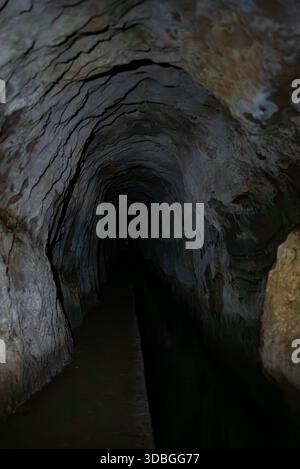 Tunnel Madeira levada con pareti in basalto e canale d'acqua di notte Foto Stock