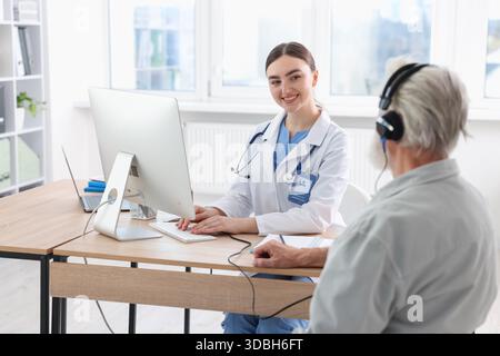 Paziente con cuffie audiometriche sottoposto a test uditivo in clinica Foto Stock