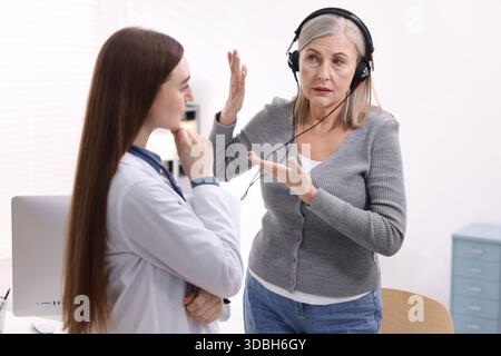 Paziente con cuffie audiometriche sottoposto a test uditivo in clinica Foto Stock